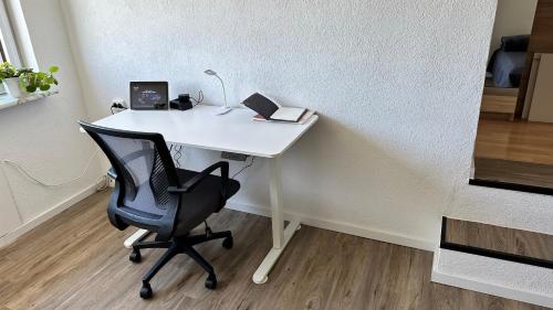 a white desk with a chair and a lamp at Traveller Awards 2025 - Nordeifel FW 75 m2 mit 50 m2 Terasse- Thermen-Badewelt, Phanasialand, Köln, Bonn, Eifelwanderung oder nur mal so zum entspannen in Euskirchen