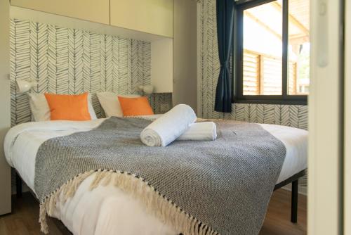 a bedroom with a large bed with orange pillows at Estivo Premium Mobile homes on Holidaypark TerSpegelt in Eersel