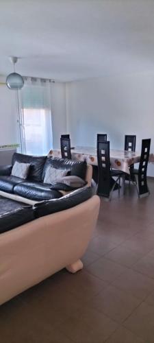 un salon avec un canapé, des tables et des chaises dans l'établissement Spacieux Appartement 90m2,résidence récente proximité stade Vélodrome et plage, à Marseille