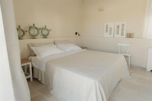 a white bed with white sheets and pillows in a bedroom at Masseria Vaccaro by Raro Villas - Self Check-in in Brindisi