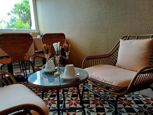 Habitación con sillas, mesa y sofá en Hôtel De La Mer - Deauville Blonville - Boutique Hôtel de charme vue Mer ou Campagne - Accès direct plage, en Blonville-sur-Mer