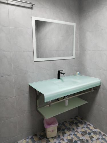 a bathroom with a green sink and a mirror at Phratamnak Inn Hotel & Guesthouse - 100 mtr from the beach in Pattaya South