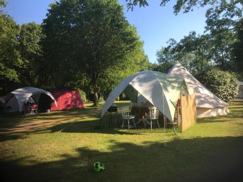 two tents and a table and chairs in a field at Camping Au Lac Du Drennec Glamping Tent in Commana