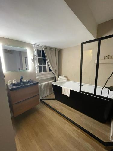 une grande salle de bain avec une baignoire et un lavabo dans l'établissement Hôtel De La Mer - Deauville Blonville - Boutique Hôtel de charme vue Mer ou Campagne - Accès direct plage, à Blonville-sur-Mer