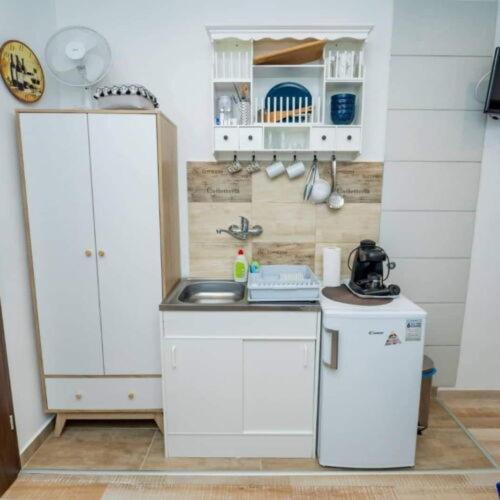 a small kitchen with white cabinets and a sink at Silver Apartments in Bogács