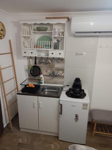 a small kitchen with white cabinets and a sink at Silver Apartments in Bogács
