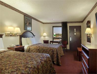 Habitación de hotel con 2 camas y escritorio en Days Inn by Wyndham Bainbridge en Bainbridge
