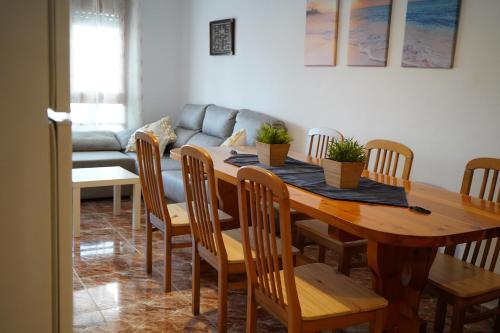 a dining room table with chairs and a couch at Chalet AMEA in Riumar