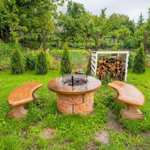 two benches sitting around a fire pit in a yard at Silver Apartments in Bogács