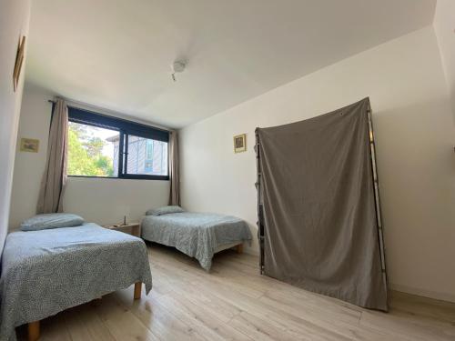 une chambre avec deux lits et un drap sur le mur dans l'établissement Land Natur, à Vielle-Saint-Girons