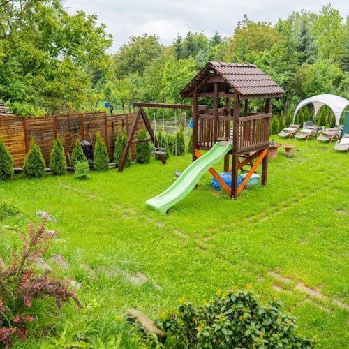a playground with a slide and a gazebo in a yard at Silver Apartments in Bogács