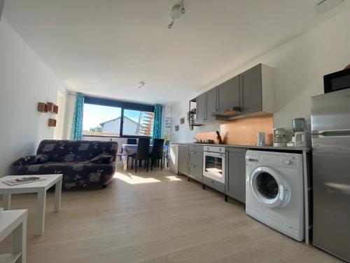 une cuisine et un salon avec une machine à laver dans l'établissement Land Natur, à Vielle-Saint-Girons