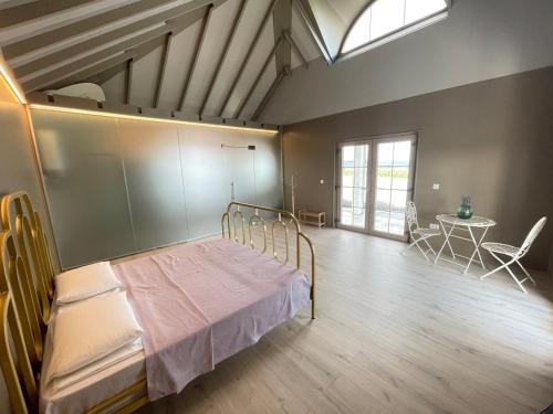 a bedroom with a bed and a table and a window at Căsuța Mov de Bucovina in Suceava