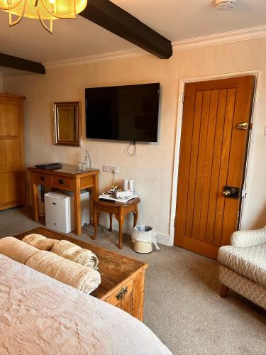 a bedroom with a bed and a desk and a television at Henwick house accommodation, Continental breakfast included in Ludlow