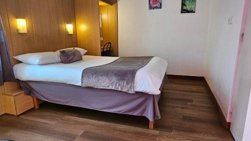 a small bedroom with a bed in a room at Brit Hotel Essentiel Pau Lescar in Lescar