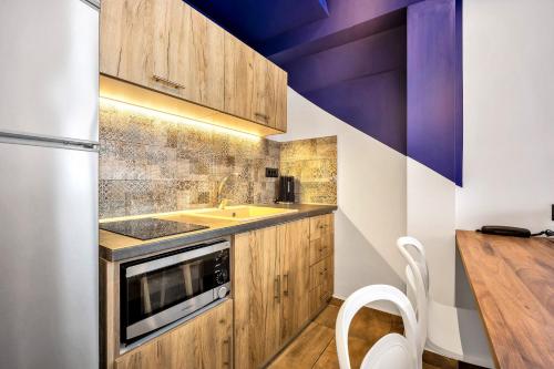 a kitchen with wooden cabinets and a sink at The Dorians in Athens