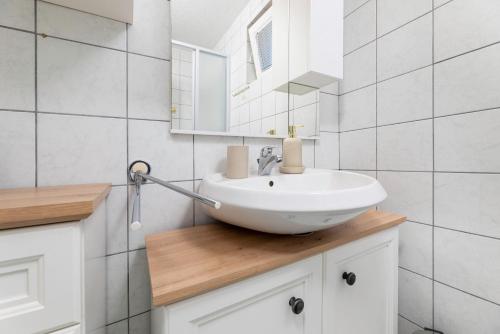 Un baño con un lavabo blanco y un espejo. en Apartments Maria, en Šilo