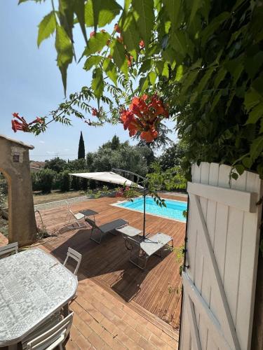 une terrasse avec une piscine, une table et des chaises dans l'établissement Belle Villa avec Piscine, au Muy