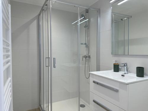 une salle de bain blanche avec une douche et un lavabo dans l'établissement L'appartement Le Levant au Lavandou, au Lavandou