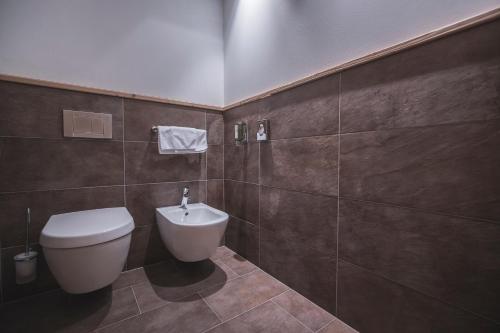 a bathroom with a toilet and a sink at Hotel Alpenblick in Sesto