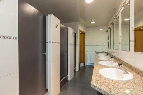 een badkamer met een rij wastafels en spiegels bij Mellow Barcelona in Barcelona