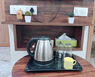a tea kettle and cups on a table at MK Luxe in Nellore