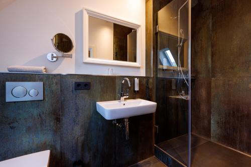 a bathroom with a sink and a shower at Logierhaus RheintorEins in Rees