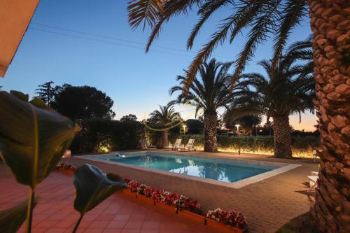 a swimming pool in a yard with palm trees at TD Villa Marinesca Typical Villa with Pool in Polignano a Mare