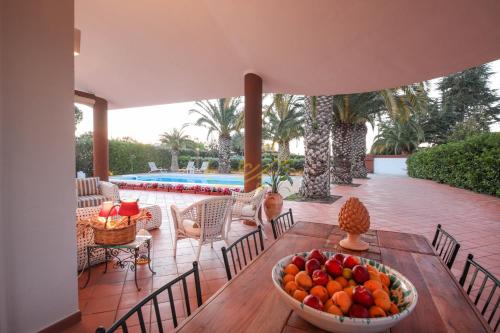 a bowl of fruit sitting on a table next to a pool at TD Villa Marinesca Typical Villa with Pool in Polignano a Mare