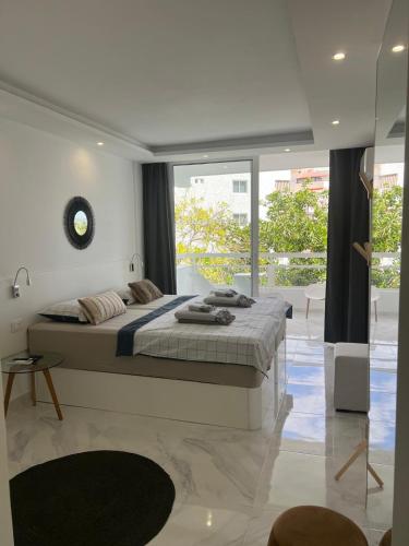 a bedroom with a large bed and a large window at Tenerife sea view 216 in Playa Fañabe