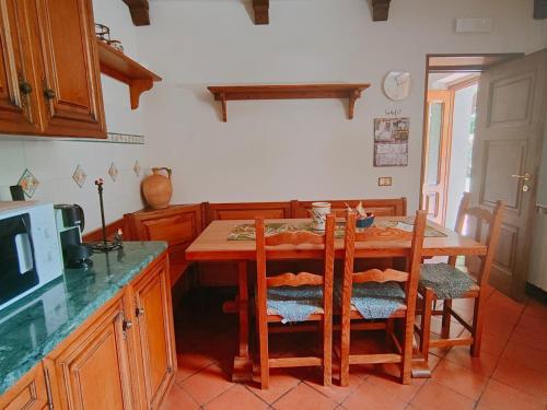 a kitchen with a table with chairs and a microwave at Casa Vacanze IL BOSCACCIO "Casa Massimo" in Fornovolasco