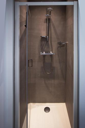 une douche avec une porte vitrée dans une salle de bain dans l'établissement La Perle, à Marseillan