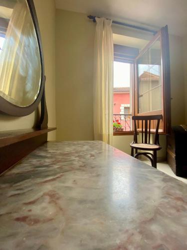 a room with a table and a mirror and a window at La Casona de Ardines in Arenas de Cabrales