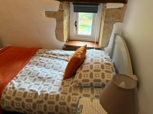 un lit dans une chambre avec une fenêtre dans l'établissement Maison chaleureuse, à Pressac