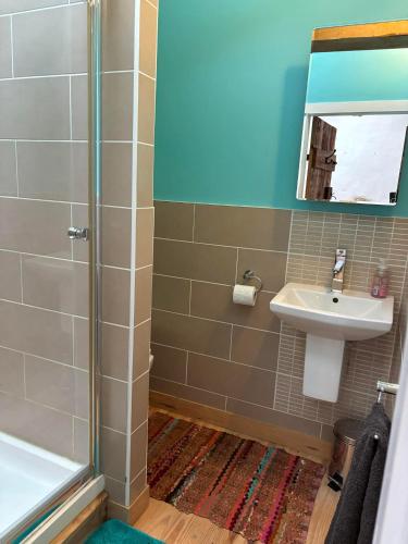 une salle de bain avec douche et lavabo dans l'établissement Maison chaleureuse, à Pressac