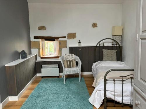 une chambre avec un lit, une chaise et une fenêtre dans l'établissement Maison chaleureuse, à Pressac