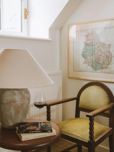 a table with a lamp and a glass of wine at Bellevigne Bourgogne in Chambolle-Musigny