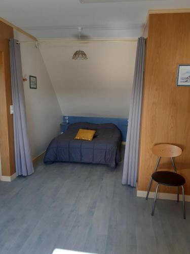 une petite chambre avec un lit et une chaise dans l'établissement Le Clos de L'aura, à Saint-Lyphard