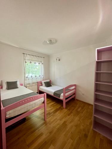 ein Schlafzimmer mit zwei Betten und einem Fenster in der Unterkunft Sarajevo Flower Garden in Vogošća