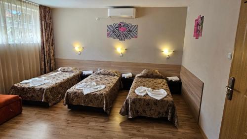 a hotel room with two beds with towels on them at Caprice Family Hotel in Varna City