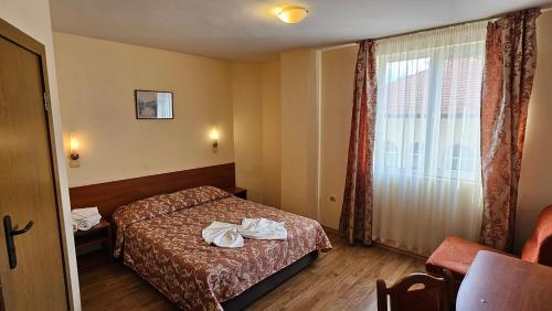 a hotel room with a bed and a window at Caprice Family Hotel in Varna City