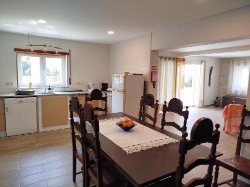 a kitchen with a table with a bowl of fruit on it at Casinha da Glória in Silva