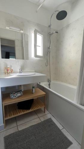 une salle de bain avec un lavabo, une baignoire et un miroir dans l'établissement Lanas Natura, à Moliets-et-Maa