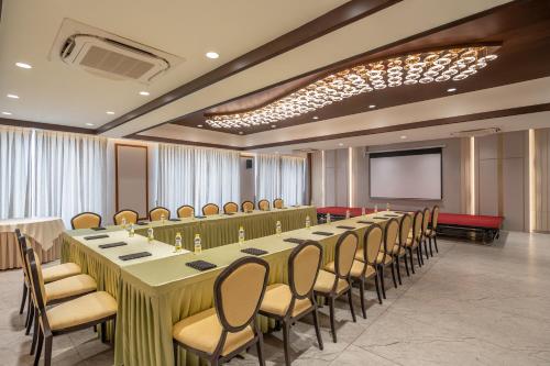 a conference room with a long table and chairs at Copper Leaf Hotels, Tirunelveli in Tirunelveli