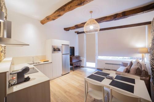 a kitchen and living room with a large window at Apartamentos Lucio Rodinso in Castroverde