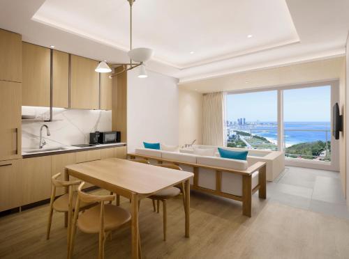 a kitchen and living room with a table and a couch at Cassia Sokcho in Sokcho