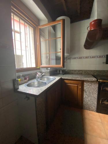 a kitchen counter with a sink and a window at La Casona de Ardines in Arenas de Cabrales
