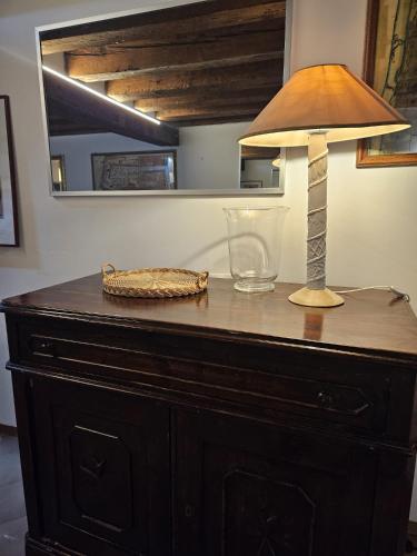 威尼斯Calle dei Furlani - Appartamento con Patio的梳妆台上带镜子的灯