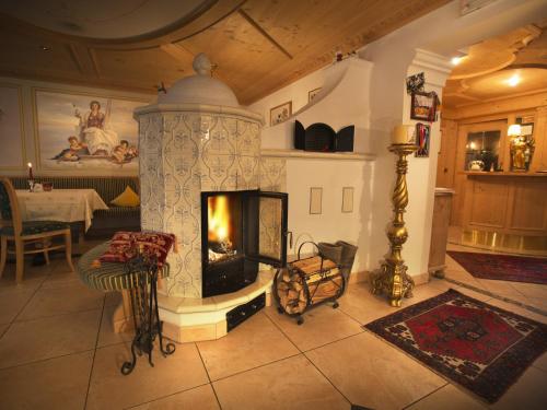 ein Wohnzimmer mit einem Kamin und einem Tisch in der Unterkunft Hotel Garni Concordia - Dolomites Home in Wolkenstein in Gröden