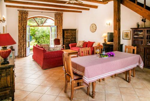 a living room with a table and a red couch at Domaine Saint Ferreol in Nizas
